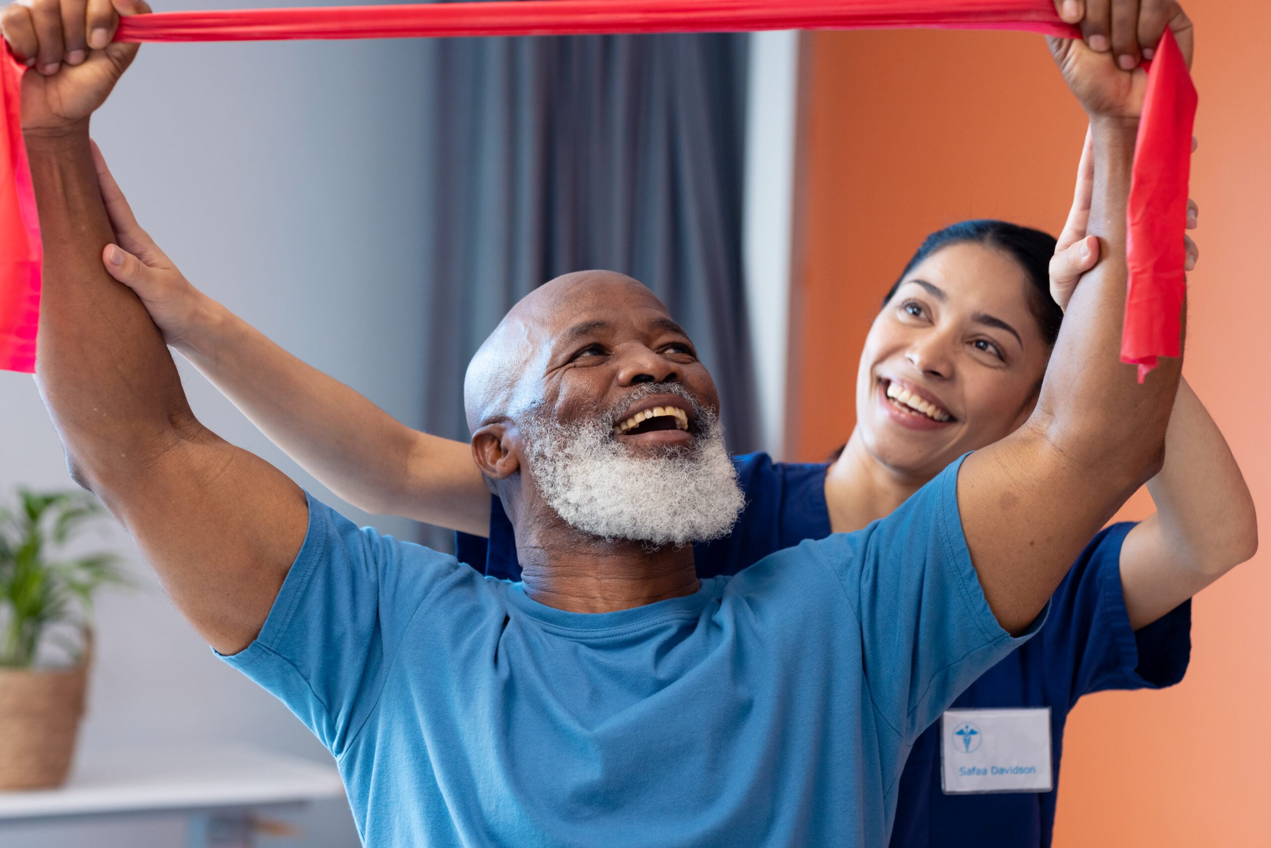 smiling diverse female physical therapist and senior patient